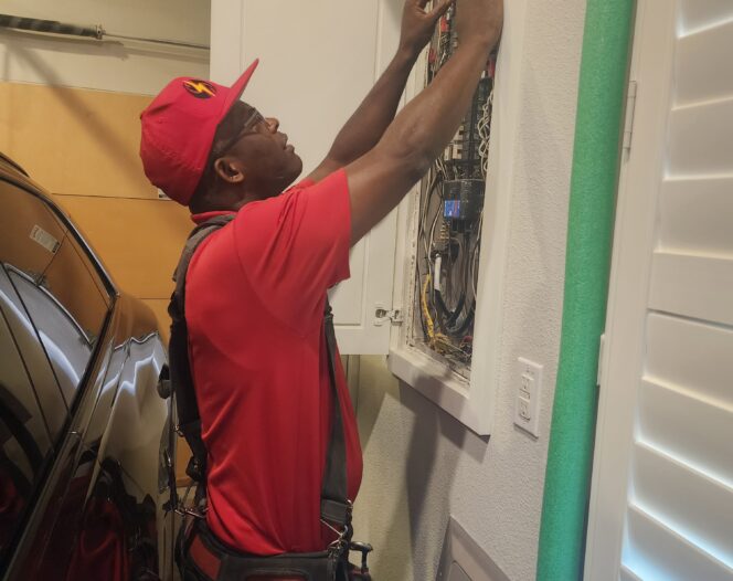 An electrician from Curren Electrical Services Inc. in uniform doing repairs